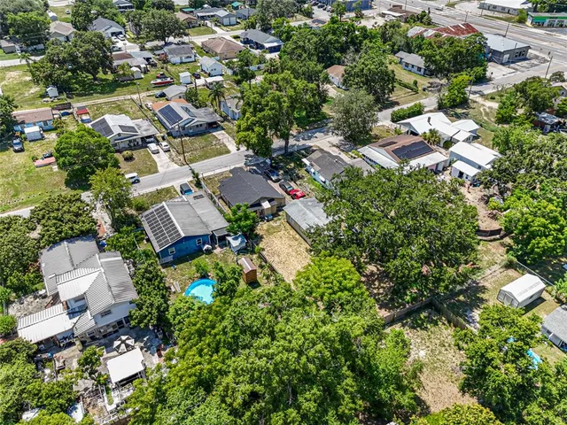 an aerial view of residential house with outdoor space and trees all around