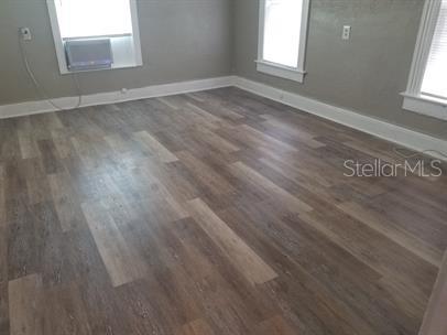 318 East Tarpon Avenue, Unit 5 Tarpon Springs, FL 34689 - Photo 4 of 16 an empty room with wooden floor and windows