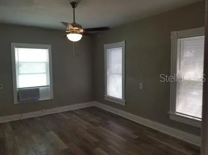 a view of wooden floor and a chandelier in an empty room