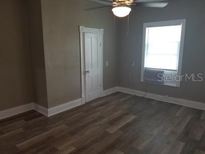 318 East Tarpon Avenue, Unit 5 Tarpon Springs, FL 34689 - Photo 6 of 16 an empty room with wooden floor and windows