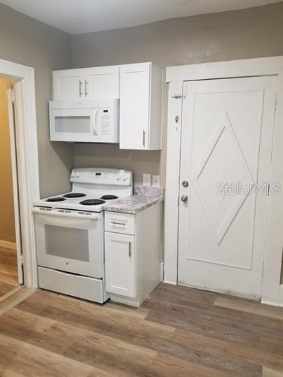 318 East Tarpon Avenue, Unit 5 Tarpon Springs, FL 34689 - Photo 8 of 16 a kitchen with white cabinets and white appliances