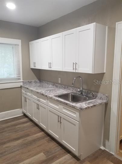 318 East Tarpon Avenue, Unit 5 Tarpon Springs, FL 34689 - Photo 9 of 16 a kitchen with granite countertop a sink and cabinets
