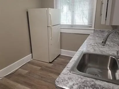 a utility room with wooden floor washer and dryer