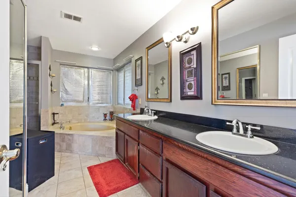 a bathroom with a tub sink and mirror