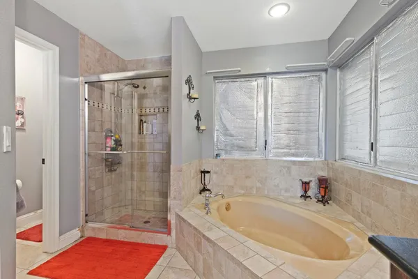 a bathroom with a tub a sink and a shower