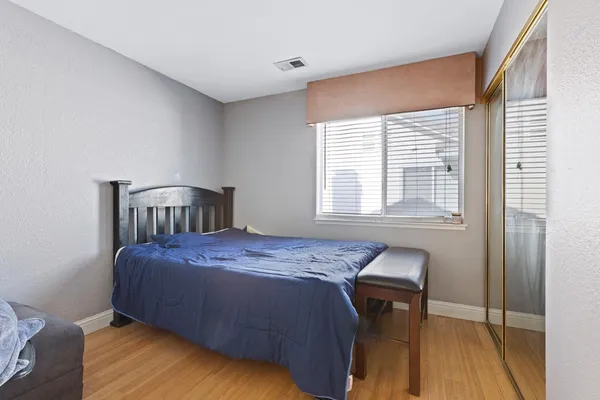 a bedroom with a bed and wooden floor
