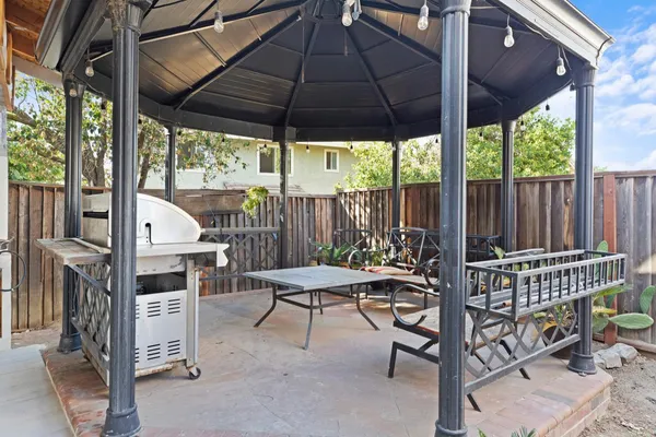 a view of a patio with a table and chairs under an umbrella