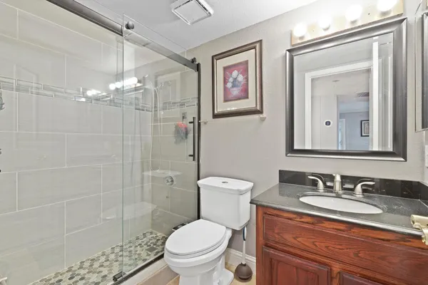 a bathroom with a granite countertop sink toilet and shower