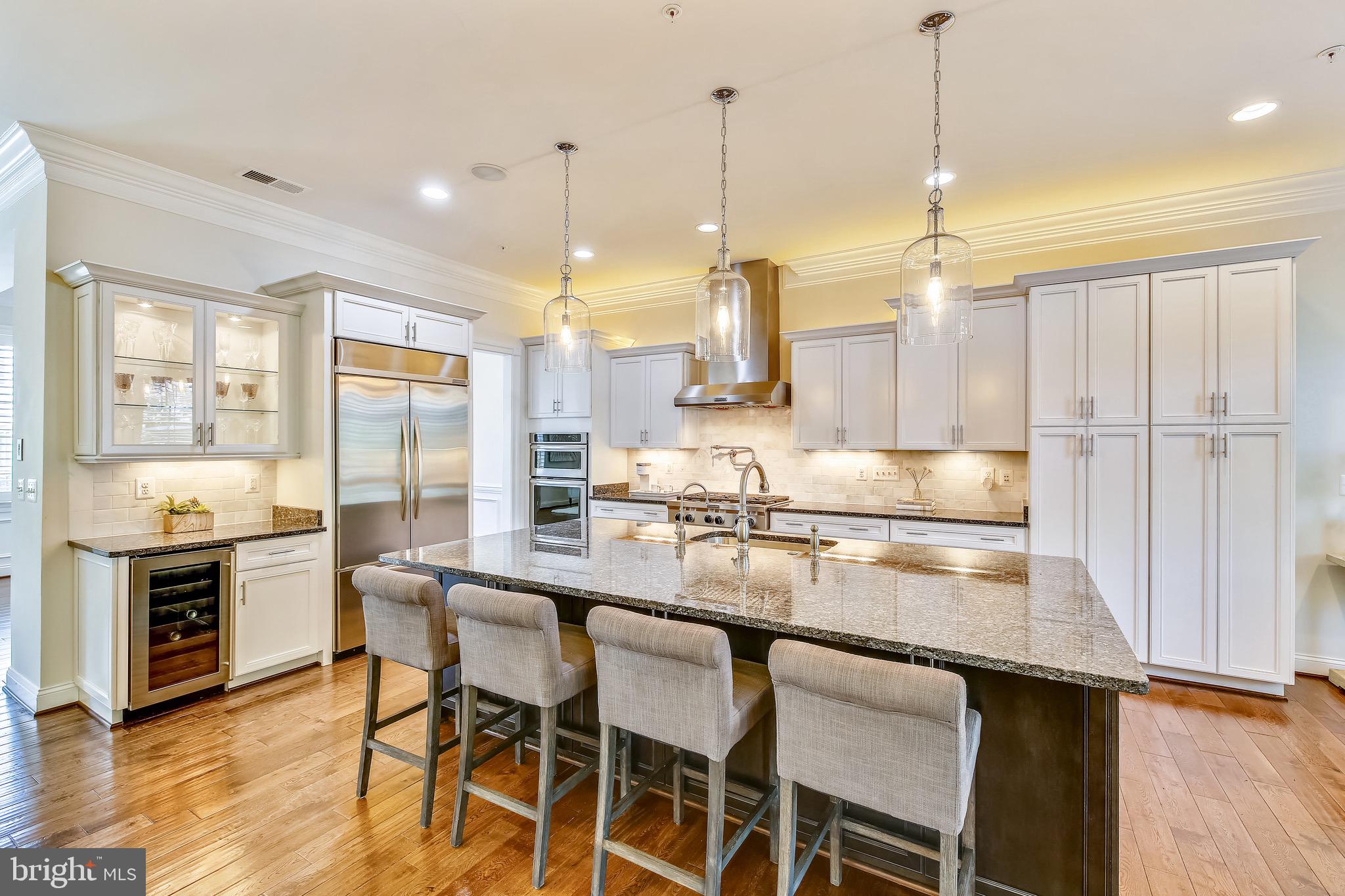 1411 Ridgeview Way Washington, DC 20007 - Photo 6 of 43 a kitchen with kitchen island granite countertop a table chairs stove and wooden floor