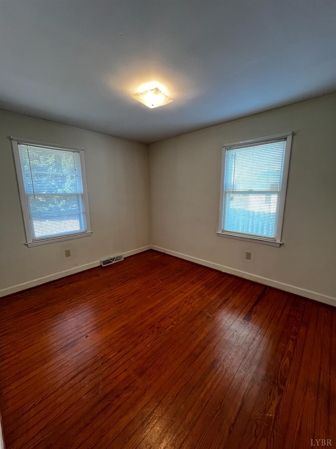 156 Doss Street Altavista, VA 24517 - Photo 15 of 15 an empty room with wooden floor and windows