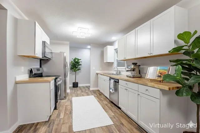 a kitchen with a white stove top oven a sink a counter space and cabinets