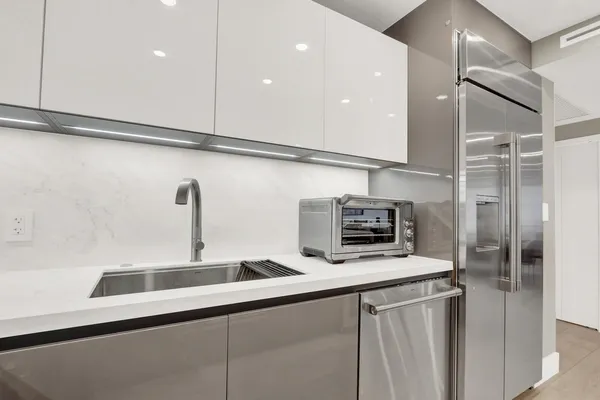 a kitchen with stainless steel appliances a sink and a refrigerator