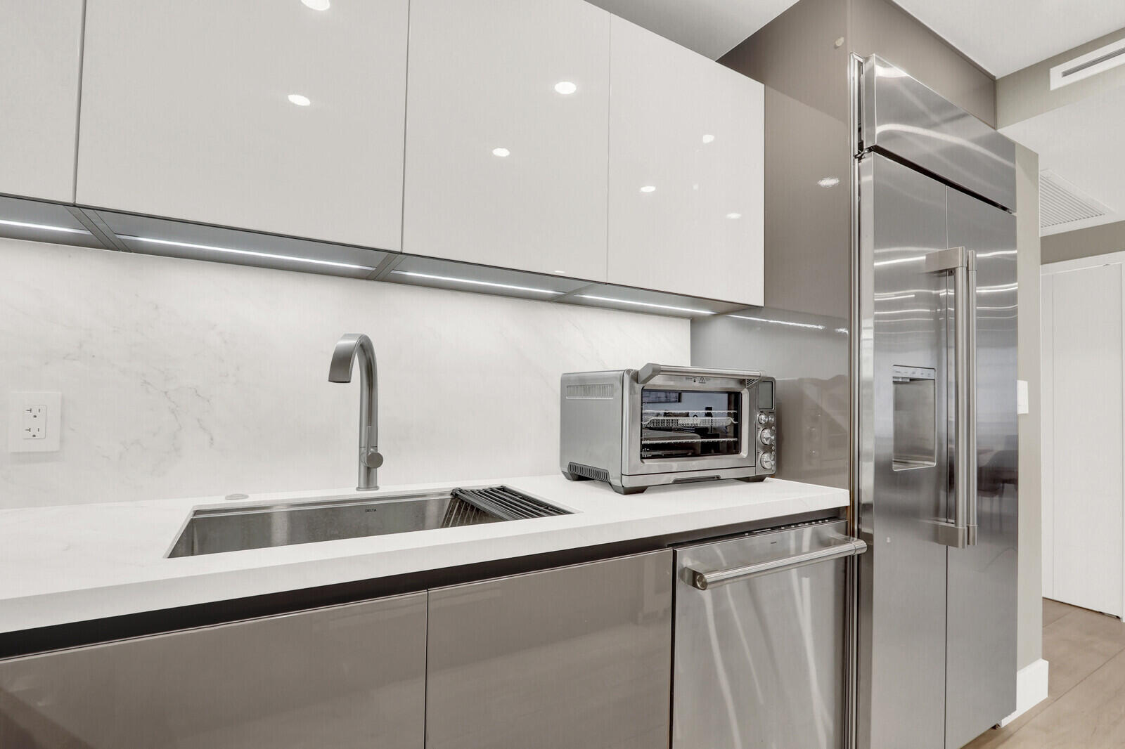 4201 North Ocean Boulevard, Unit C1202 Boca Raton, FL 33431 - Photo 12 of 47 a kitchen with stainless steel appliances a sink and a refrigerator