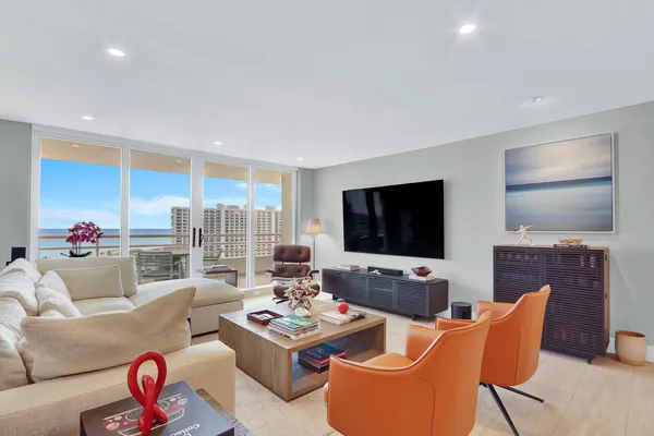 a living room with furniture kitchen view and a flat screen tv