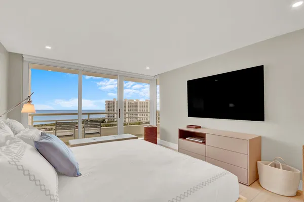 a bedroom with a bed a television and a large window