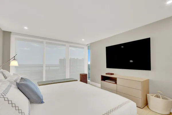 a bedroom with a bed and a flat screen tv