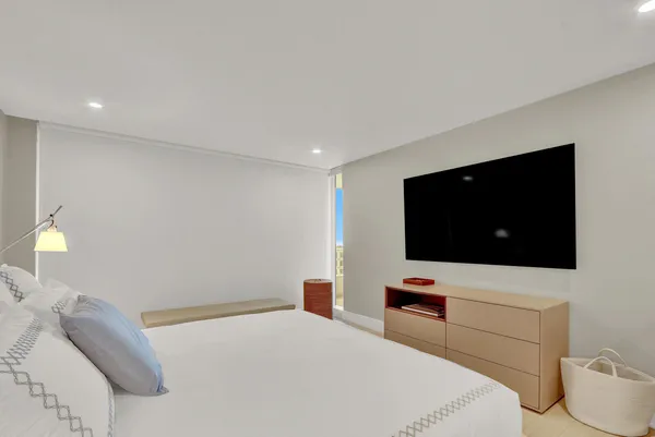 a bedroom with a bed and a flat screen tv