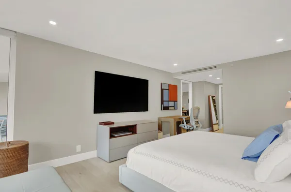 a bedroom with a bed and a flat screen tv