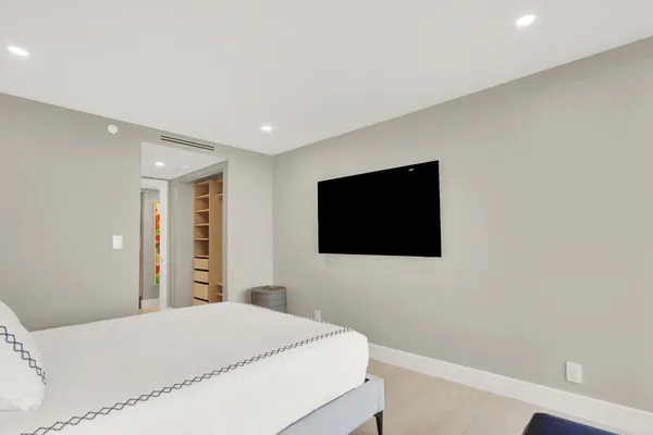 a bedroom with a bed and a flat screen tv