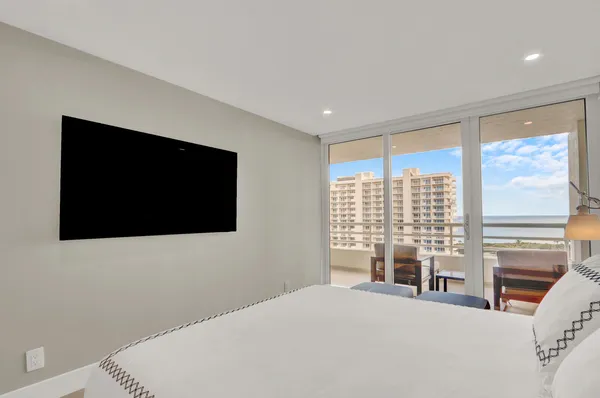 a bedroom with a bed and a flat tv screen next to a window