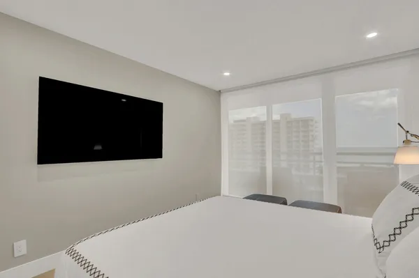 a bedroom with a bed and a flat screen tv