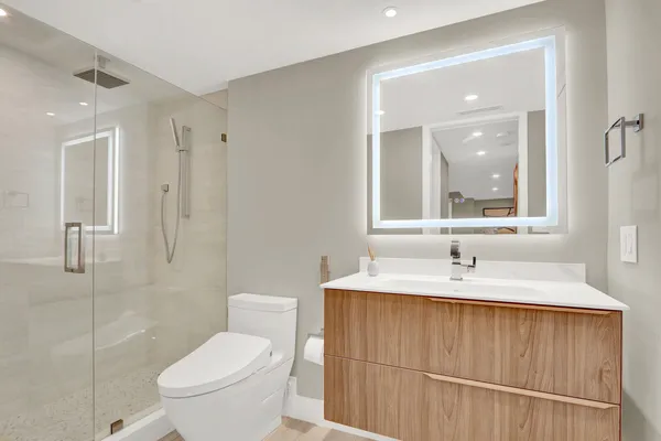 a bathroom with a toilet sink and mirror