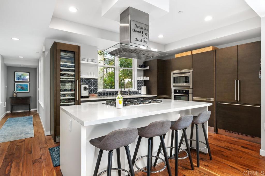 215 2nd Street, Unit 101 Encinitas, CA 92024 - Photo 15 of 47 a kitchen with stainless steel appliances a dining table chairs and granite counter tops