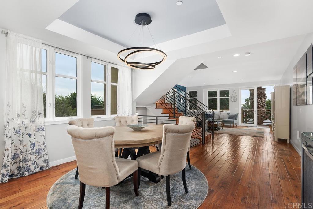 215 2nd Street, Unit 101 Encinitas, CA 92024 - Photo 16 of 47 a dining room with furniture a chandelier and wooden floor