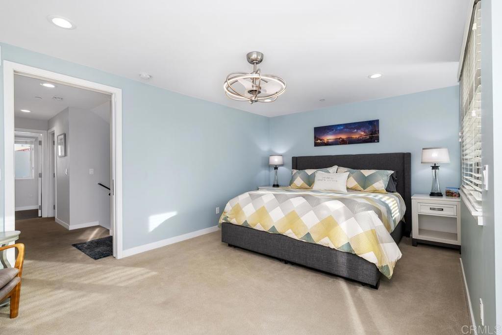 215 2nd Street, Unit 101 Encinitas, CA 92024 - Photo 27 of 47 a bedroom with a bed and a chandelier