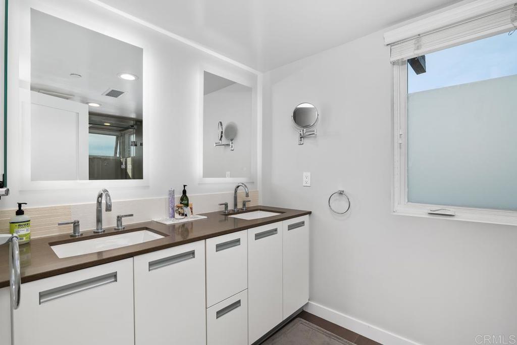 215 2nd Street, Unit 101 Encinitas, CA 92024 - Photo 29 of 47 a bathroom with a sink and a mirror