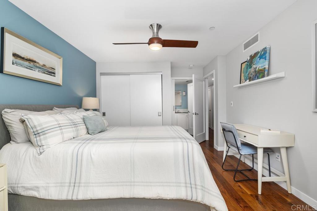 215 2nd Street, Unit 101 Encinitas, CA 92024 - Photo 43 of 47 a bedroom with a large bed and a chandelier