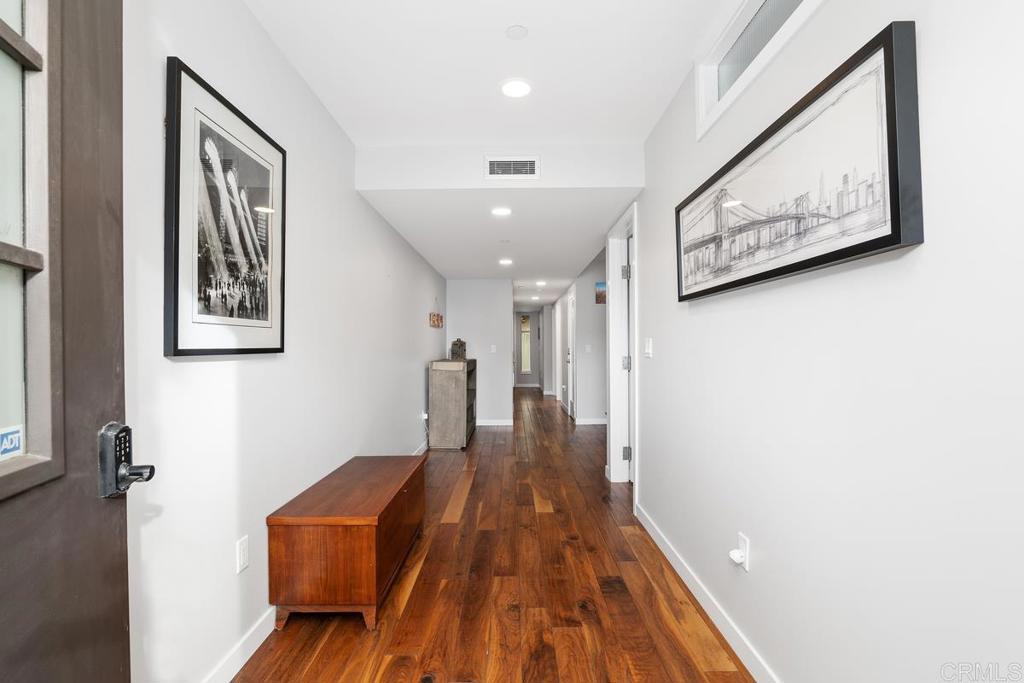 215 2nd Street, Unit 101 Encinitas, CA 92024 - Photo 7 of 47 a view of a hallway with wooden floor and staircase