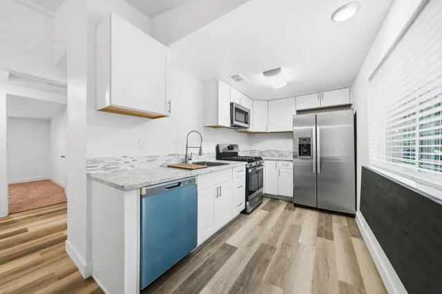 a kitchen with granite countertop a sink a counter space stainless steel appliances and cabinets