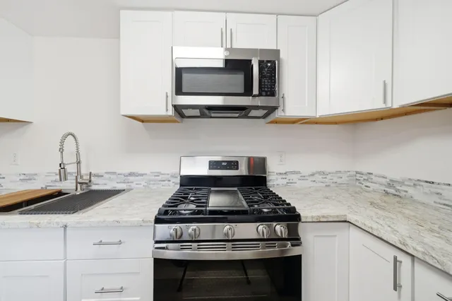 a stove top oven sitting inside of a kitchen