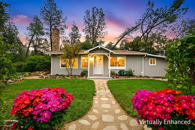 a front view of a house with backyard and garden