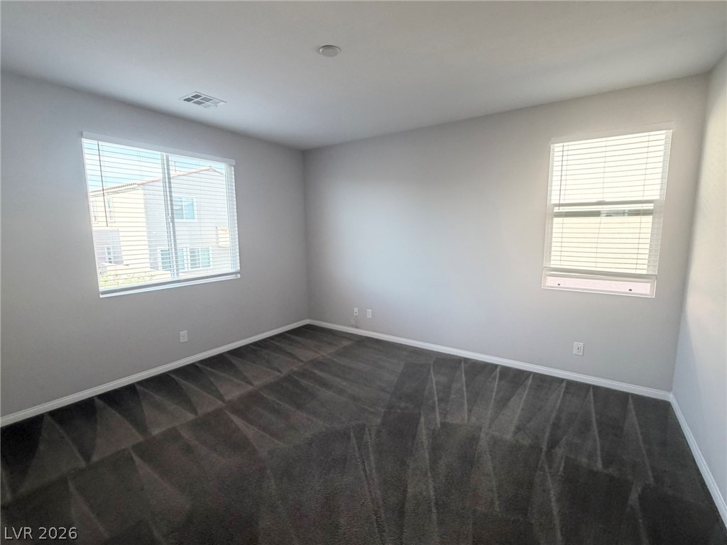 9953 Tucket Point Court Las Vegas, NV 89178 - Photo 15 of 22 Well-lit room with plush carpeting and natural light filtering through dual windows.