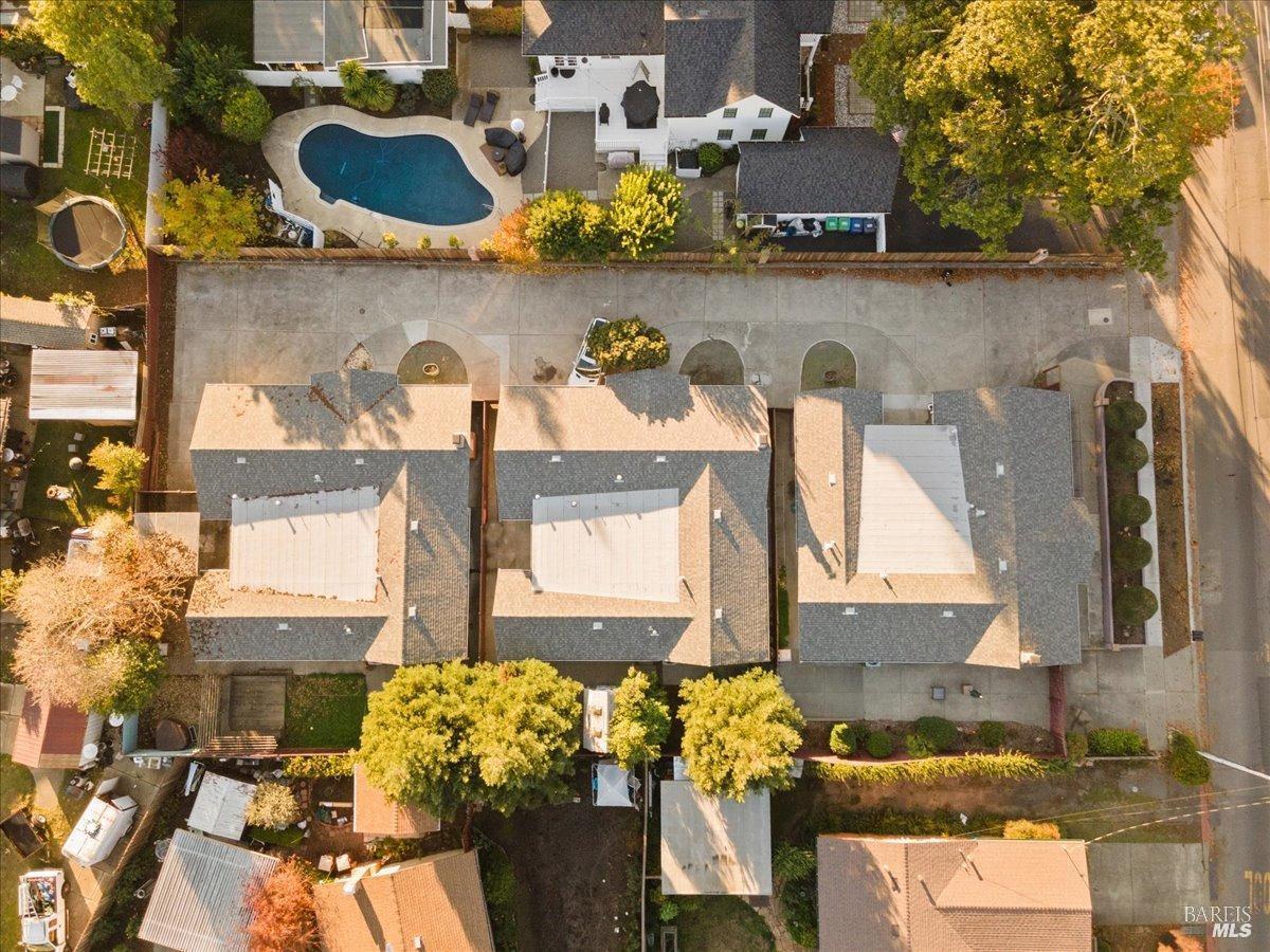 2239 Redwood Road, Unit ABC Napa, CA 94558 - Photo 1 of 20 Drone shot of three houses. One faces Redwood, the other two face driveway. Hardscape allows for additional parking and easy streamlined maintenance. House facing Redwood, has additional driveway parking.