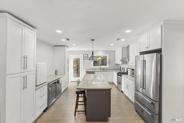 a kitchen with white cabinets and stainless steel appliances