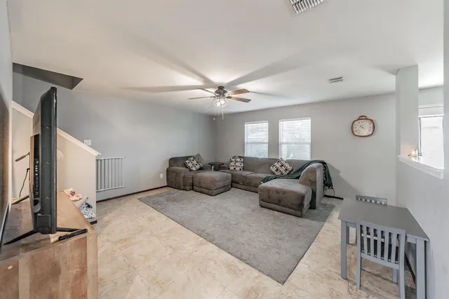 a living room with furniture ceiling fan and a window