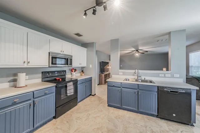 a kitchen with stainless steel appliances granite countertop a sink dishwasher stove and refrigerator