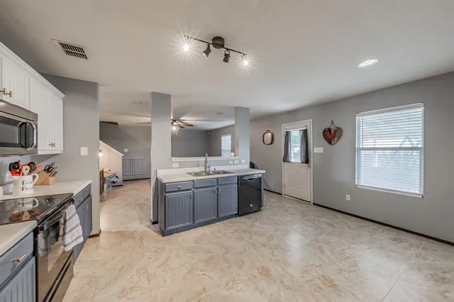 a large kitchen with cabinets and stainless steel appliances