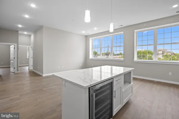 a open kitchen with stainless steel appliances granite countertop a sink dishwasher and a open refrigerator