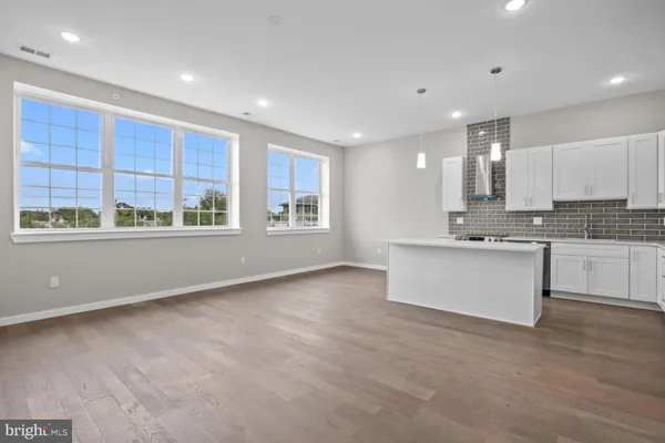 a large kitchen with stainless steel appliances granite countertop a large window a sink and a stove