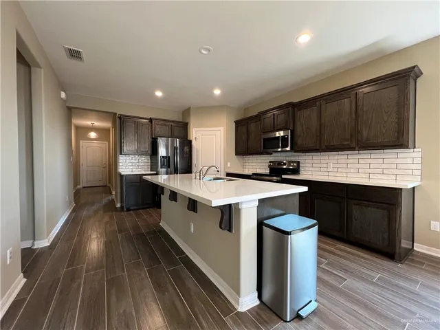 a kitchen with a sink stove top oven and cabinets