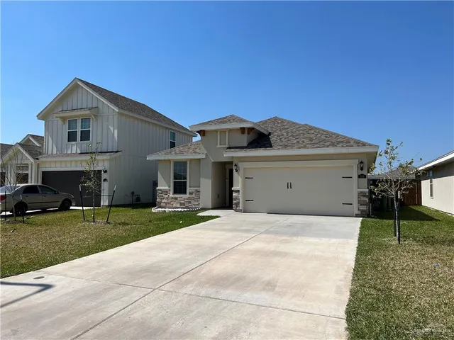 a front view of a house with a garden and yard