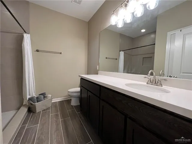 a bathroom with a double vanity sink toilet and a mirror