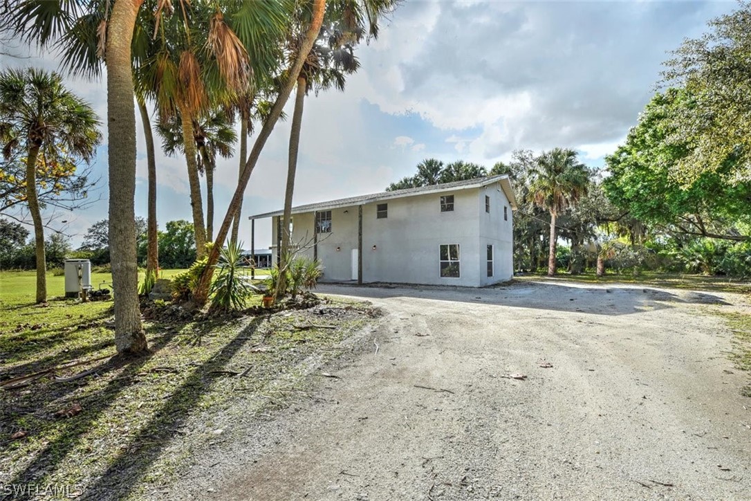 5320 Obannon Road Fort Myers, FL 33905 - Photo 19 of 28 a backyard of a house with table and chairs under an umbrella