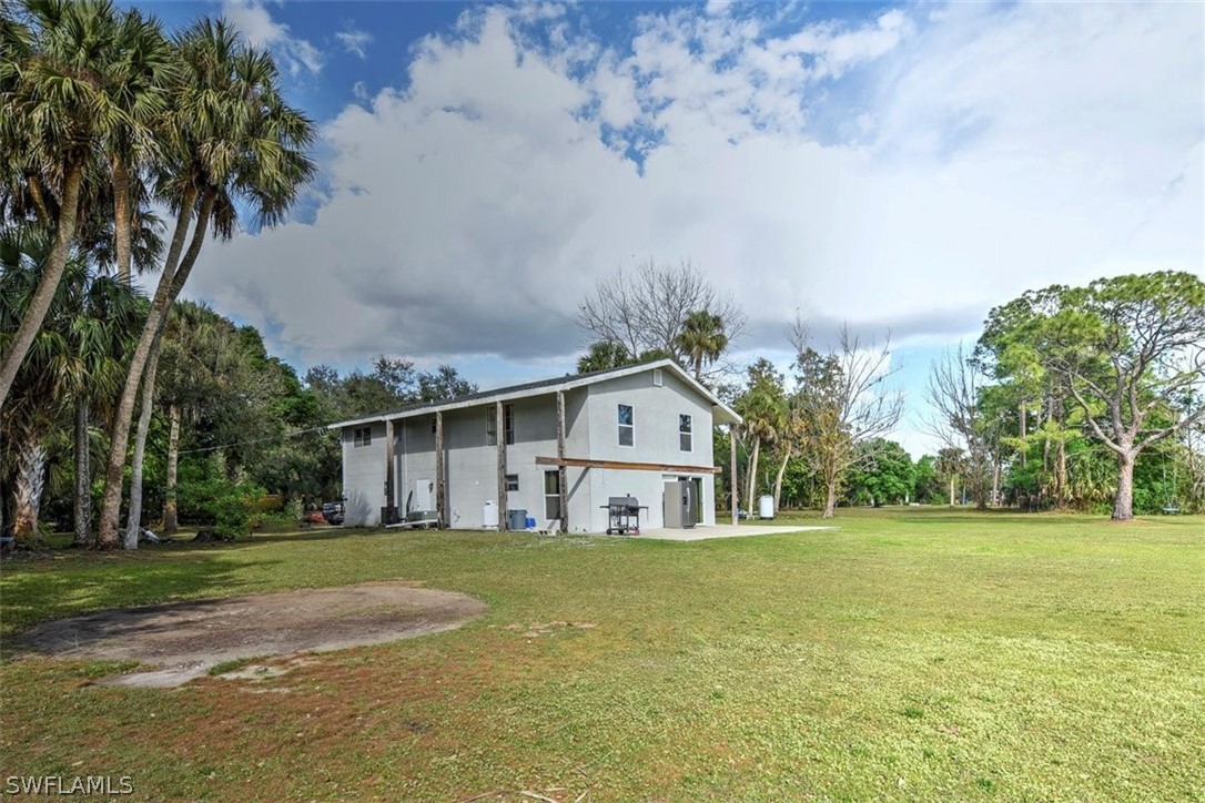 5320 Obannon Road Fort Myers, FL 33905 - Photo 25 of 28 a front view of house with yard and trees in the background