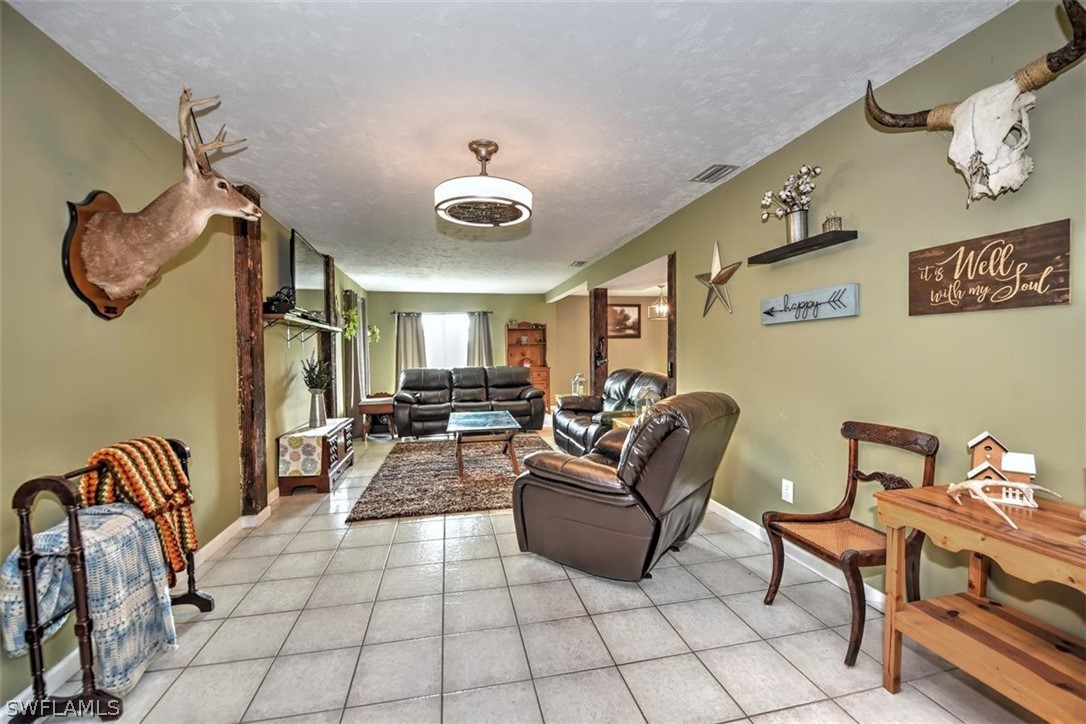 5320 Obannon Road Fort Myers, FL 33905 - Photo 3 of 28 a living room with furniture and a chandelier