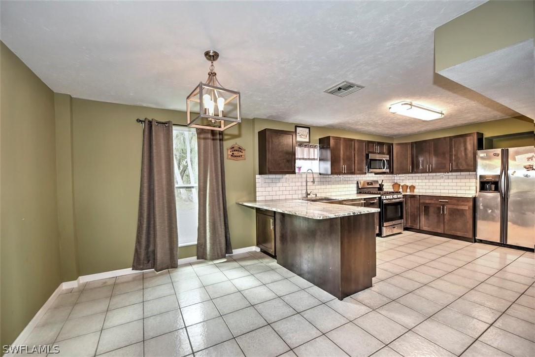 5320 Obannon Road Fort Myers, FL 33905 - Photo 6 of 28 a kitchen with stainless steel appliances a refrigerator and a sink
